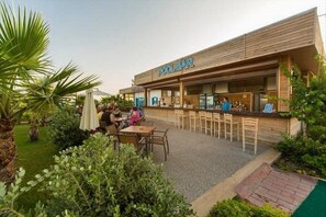 An outdoor pool bar with wooden seating and a bar counter. - Eftalia Marin Resort (Alanya)