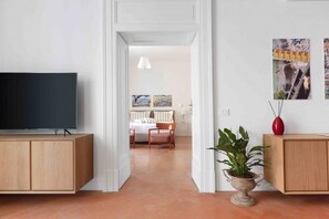 A modern living room with a flat-screen TV, wooden cabinets, a potted plant, and a painting on the wall. - Deluxe Home in Sorrento Old Town with Balconies (Sorrento)