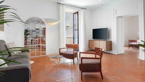 A spacious living room with a sofa, chairs, a TV, and a dining area. - Deluxe Home in Sorrento Old Town with Balconies (Sorrento)
