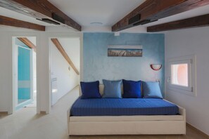 Une chambre à coucher avec un lit, un tableau et une fenêtre.