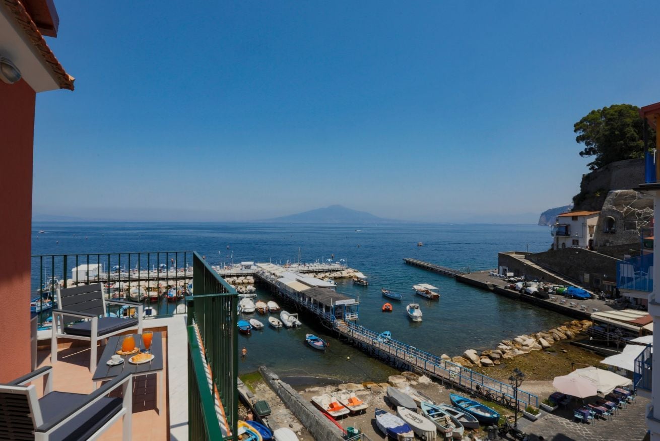 A coastal view with a marina, boats, and a distant mountain.