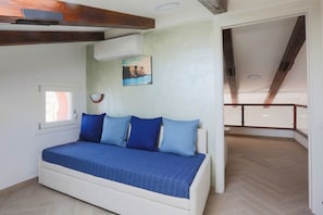 Un dormitorio con cama, ventana y un cuadro en la pared.