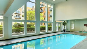 Ein Hallenbad mit großen Fenstern und Blick auf Wohnhäuser.