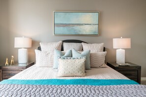 A neatly made bed with a quilted cover, two bedside tables with lamps, and a painting on the wall. - City ★ Water View Oasis with Pool & Gym near Cruise in Heart of Seattle (Seattle)