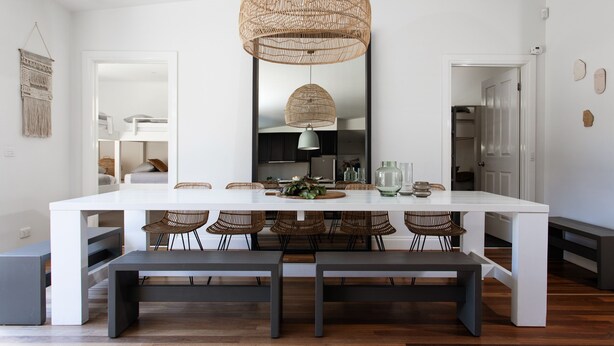 A modern dining area with a white table, wicker chairs, and a large woven pendant light. - Fingal House-Ultimate Escape for Groups, Families & Retreats (Fingal)