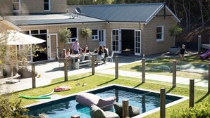 Un jardin avec une piscine, un espace patio et un coin jeux.