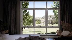A bedroom with a large window, a bed, a chair, and a bedside table. - Fingal House-Ultimate Escape for Groups, Families & Retreats (Fingal)