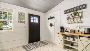 Una cocina con barra de café, un letrero de bienvenida y decoración rústica.