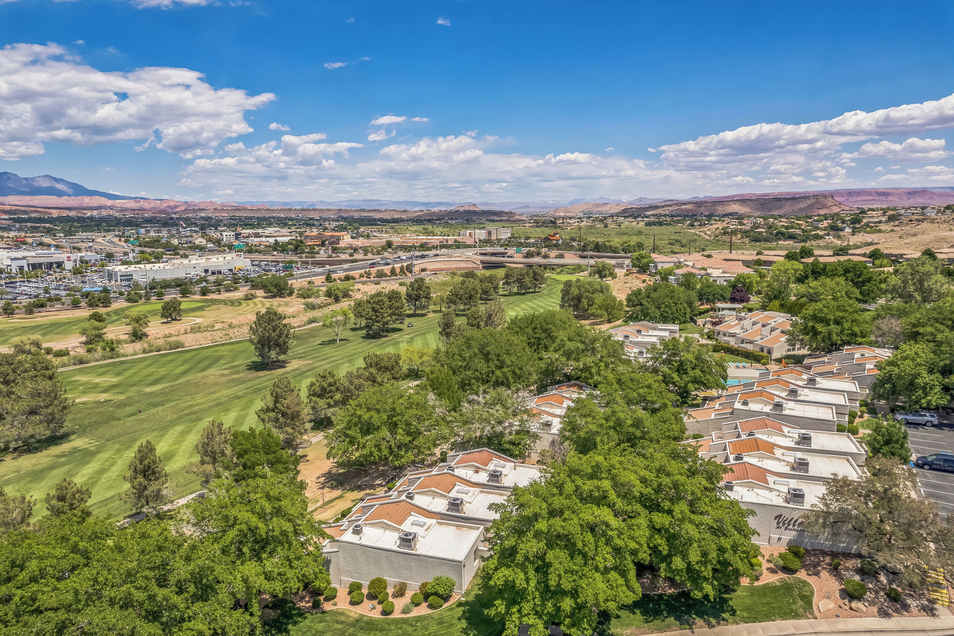 A residential area with houses, green lawns, and a golf course.