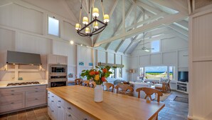 Una cocina amplia con una isla grande, electrodomésticos modernos y vistas al exterior.