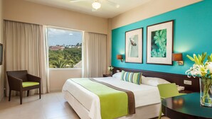 Habitación de hotel con una cama, una silla, un escritorio y vistas al exterior.