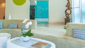 Un vestíbulo moderno con lámparas colgantes que parecen de papel, un conjunto de sofás, una mesa de centro y una escultura decorativa.