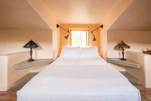 A bedroom with a large bed, two bedside tables, and a window with a view. - Serene Two Story Home,  Private 43 acre Private Property (Canones)
