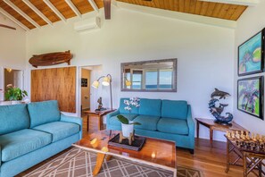 A living room with two teal sofas, a wooden coffee table, and a chessboard.