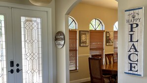 A foyer with a white door, a 'Welcome to our Home' sign, a 'Cafe de Paris' sign, and a 'This is my HAPPY PLACE' sign. - Vacation Rental Home in Bonita Springs (Bonita Springs)