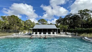 A swimming pool with clear water, surrounded by lounge chairs and a covered pavilion. - Vacation Rental Home in Bonita Springs (Bonita Springs)