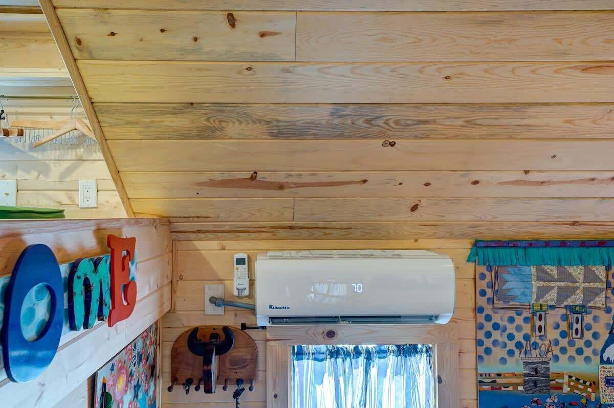 A wooden ceiling with a mounted air conditioner and a wall with a 'HOME' sign.