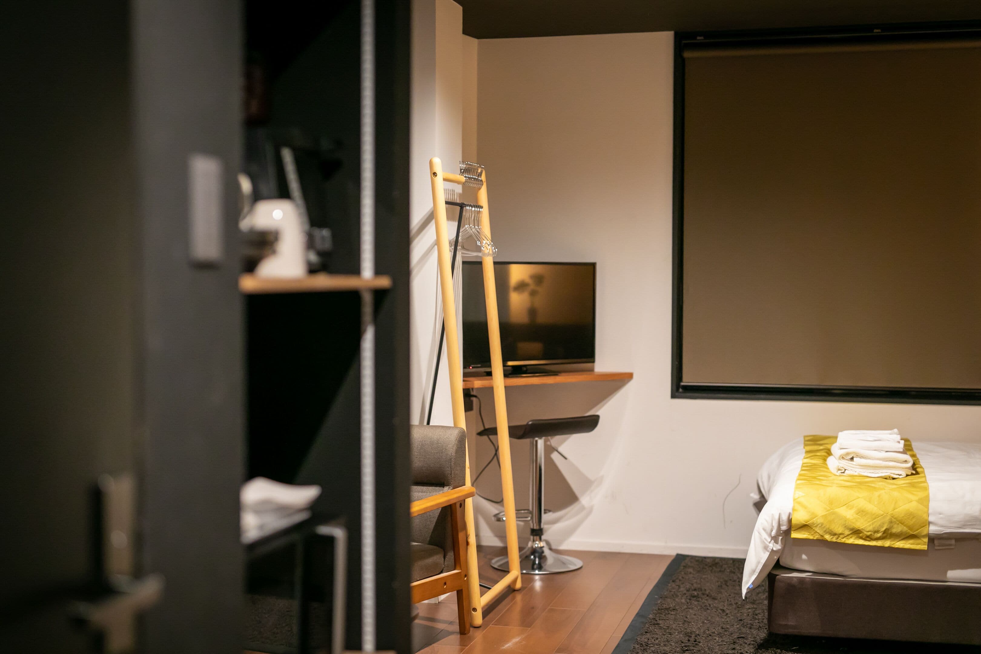Una camera d'albergo moderna con un letto, una scrivania e una televisione.