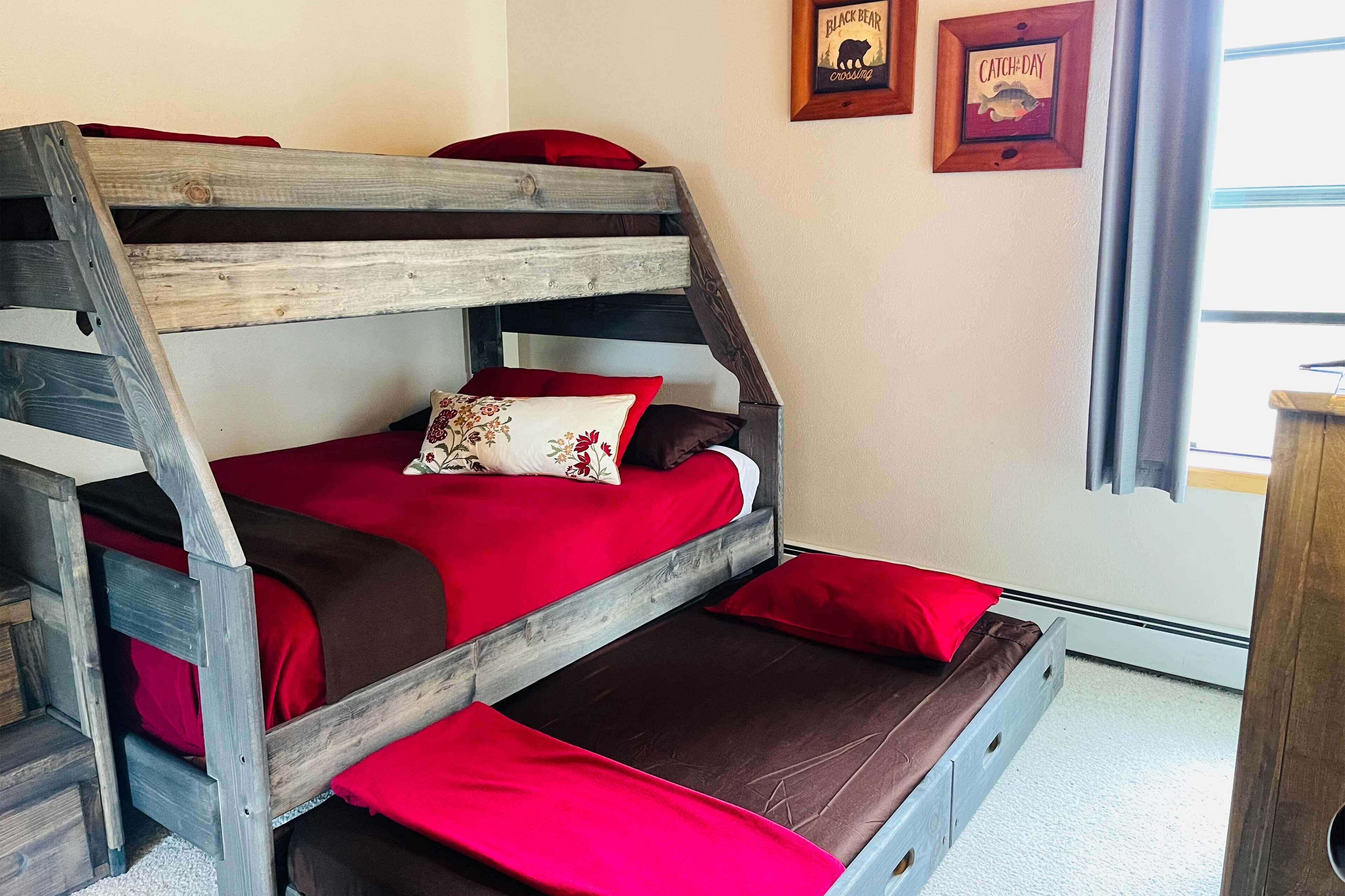 A bunk bed with red bedding and a wooden headboard.