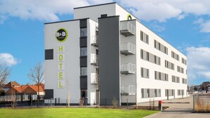Moderni bed & breakfast -tyyppinen hotelli, jossa on valkoinen julkisivu, parvekkeet ja avoin taivas.
