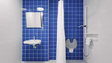 Un baño con lavamanos blanco, espejo, ducha y paredes con azulejos azules.