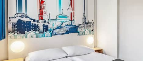 A hotel room with a bed, a nightstand, and a large cityscape artwork on the wall.
