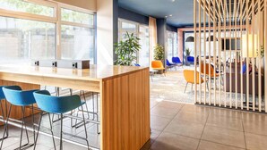 Ein modernes Interieur mit Barbereich, Sitzgelegenheiten und großen Fenstern.
