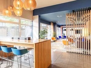 Ein modernes Interieur mit Barbereich, Sitzgelegenheiten und großen Fenstern.
