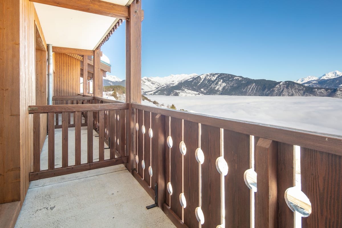 Ein Holzbalkon mit Blick auf schneebedeckte Berge.