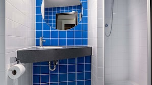 A bathroom with a sink, mirror, and shower. - B&B HOTEL Stuttgart-Airport/Messe (Stuttgart)