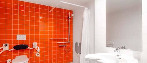 Un baño con lavamanos blanco, inodoro y zona de ducha.