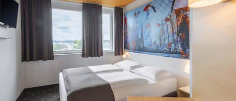 A hotel room with a bed, a desk, a TV, and a large window with curtains.