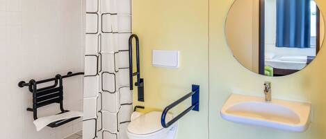 Un baño con inodoro blanco, lavabo, espejo y cortina de ducha.