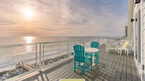 A deck with outdoor seating, overlooking a beach and ocean. - Sea Turtle - Luxury 7BR Beachfront Retreat, Private Pool, 5 Star Reviews! (Panama City Beach)