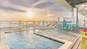 A pool area with a view of the sunset over the ocean, wooden deck, and outdoor seating. - Sea Turtle - Luxury 7BR Beachfront Retreat, Private Pool, 5 Star Reviews! (Panama City Beach)