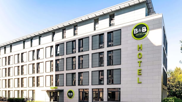 Un moderno edificio de hotel con un llamativo letrero de 'B&B Hotels' en la fachada.