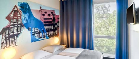 Une chambre d’hôtel avec un lit, une fresque murale, une fenêtre avec des rideaux et un téléviseur à écran plat.