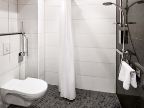 Ein modernes Badezimmer mit Toilette, einer Dusche mit Glastür und einem Handtuchhalter.