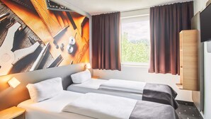 Hotelkamer met twee bedden, een groot raam met gordijnen, een wandtelevisie en een houten kledingkast.
