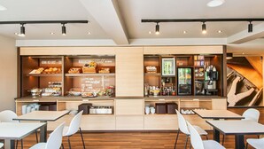 Een moderne ontbijtruimte met een buffet, koffieapparaat en zitgedeelte.