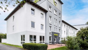 Een modern hotelgebouw met een opvallend ‘HOTEL’-bord op de gevel, een receptie en een verzorgd uiterlijk.