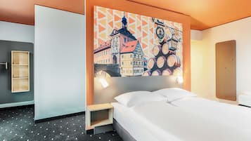 Ein Hotelzimmer mit einem Bett, einem Nachttisch, einer Wandablage und einem großen Stadtbild.