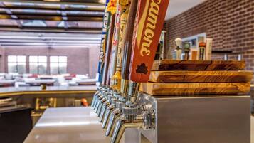 A row of beer taps with labels, a brick wall, and a counter in the background.