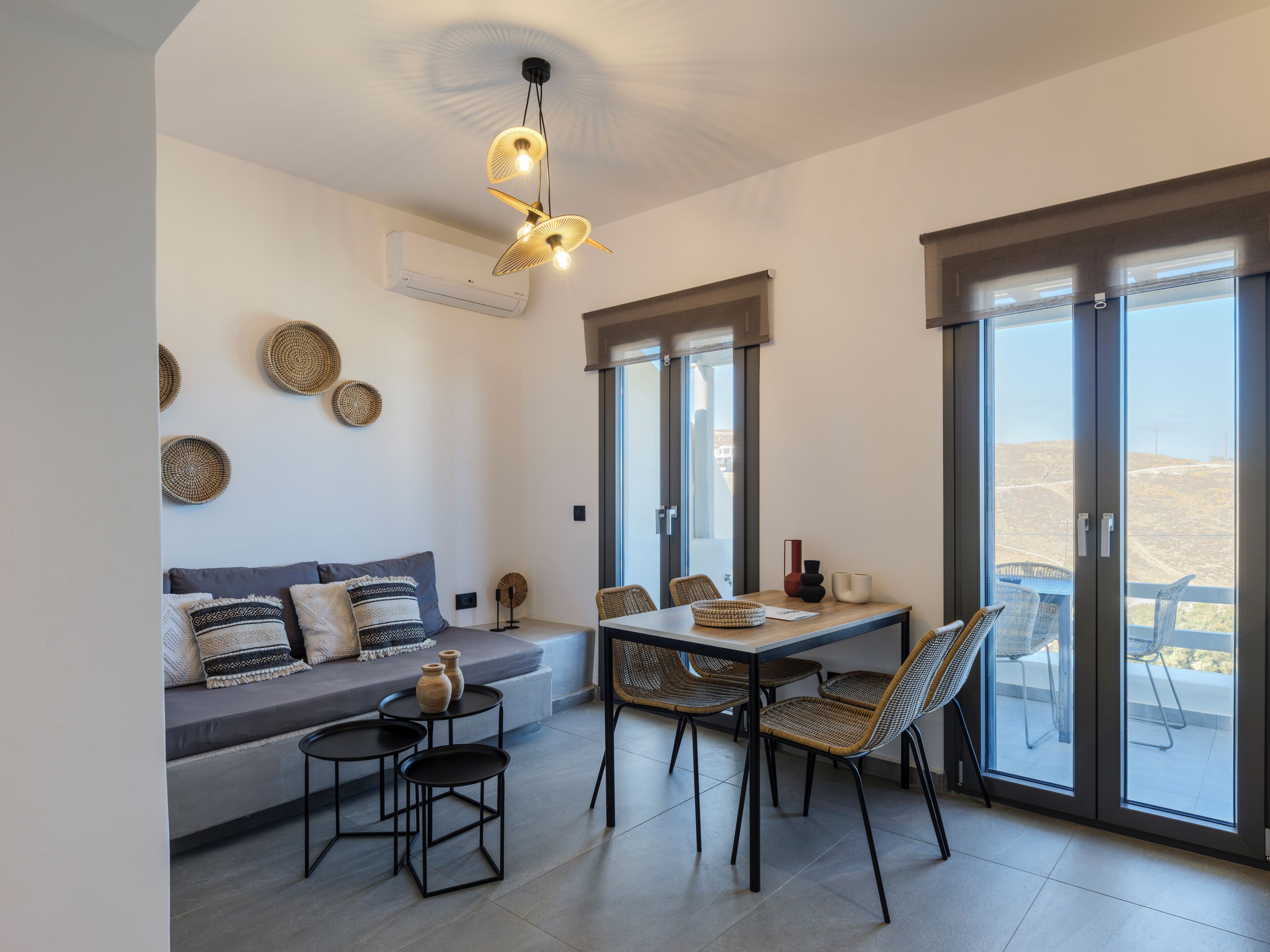 Un espace repas moderne comprenant une table, des chaises et un luminaire suspendu au plafond.