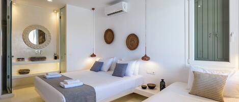 Un dormitorio moderno con dos camas, un espejo grande y una lámpara colgante.