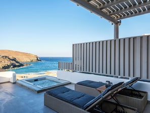 A rooftop terrace with a hot tub, wicker lounge chairs, and a view of the ocean. - Mykonos Residence Villas & Suites (Mykonos)