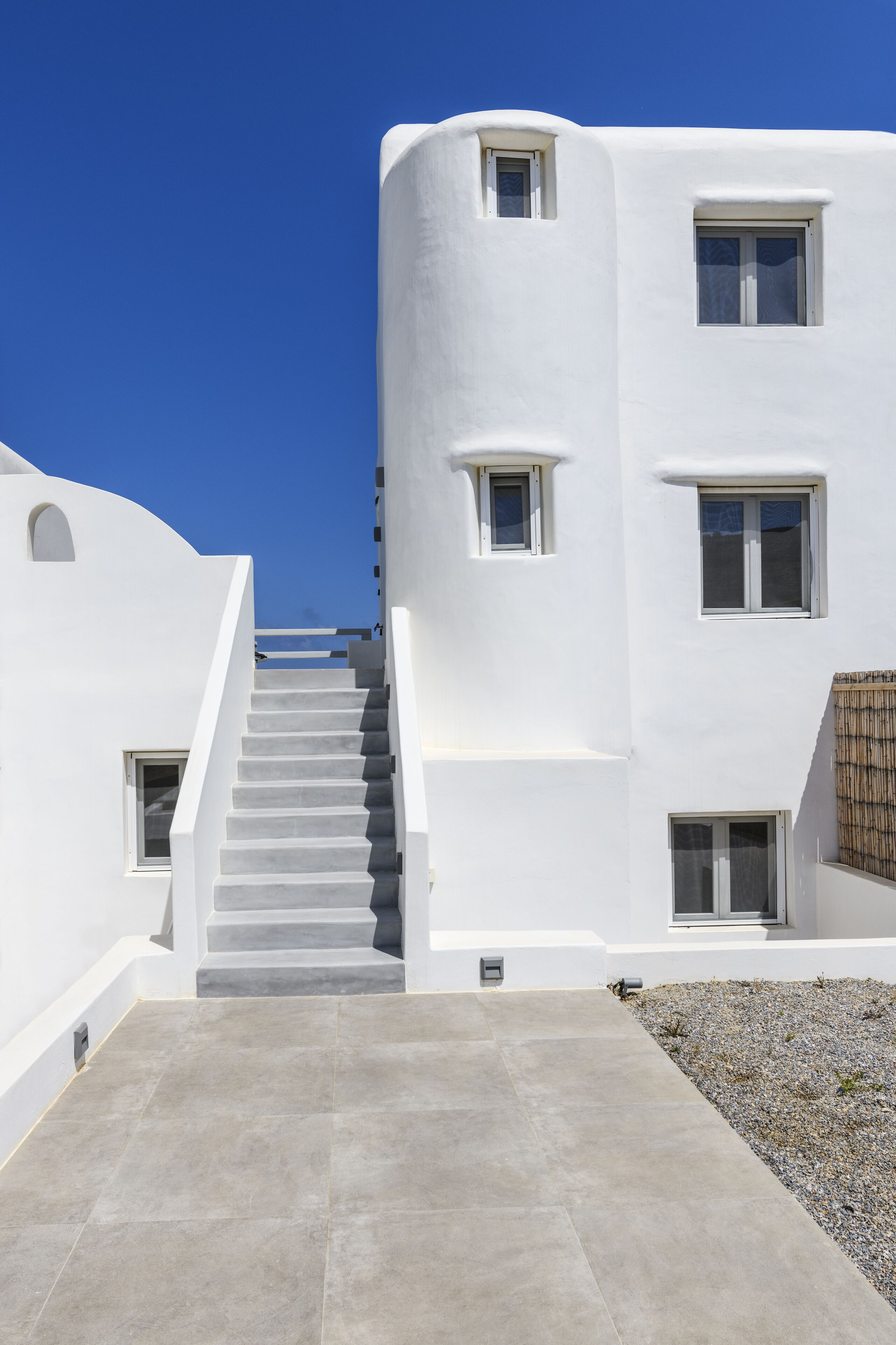 A white building with a staircase leading to a second floor.