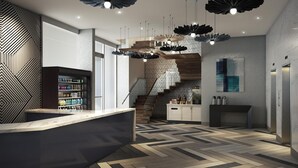 A modern interior with a herringbone-patterned floor, a central staircase, and a bar area with a variety of beverages. - Hyatt Place New York / Chelsea (New York)