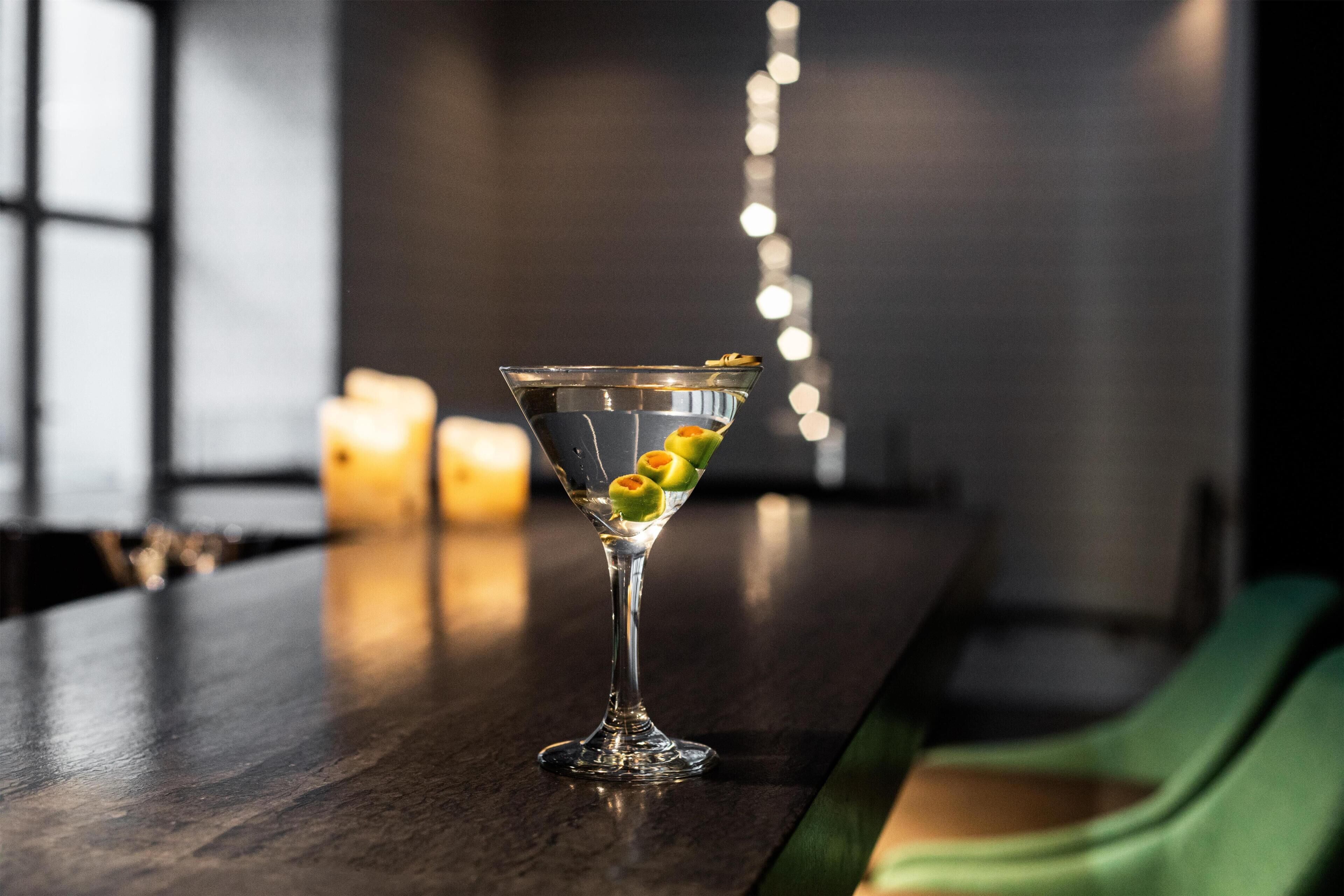 A martini glass with a garnish on a bar counter.