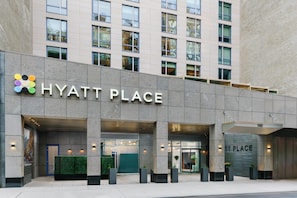 Un edificio moderno con el letrero 'HYATT PLACE', que indica un hotel.